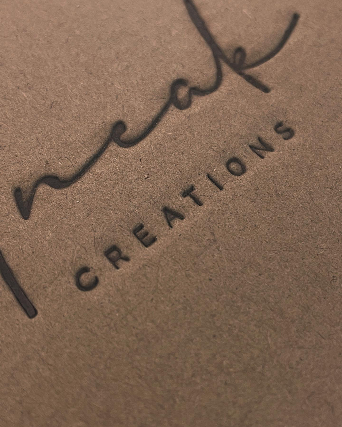 Actual archival electric-branding result on our cardboard packaging under the Uneak Creations name